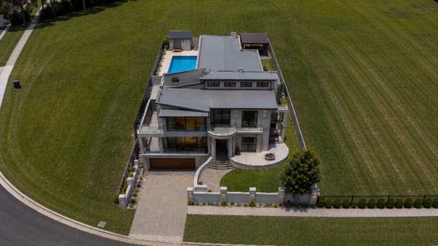 Aerial view of a finished two storey rendered home with a pool, the last frame of the build timelapse